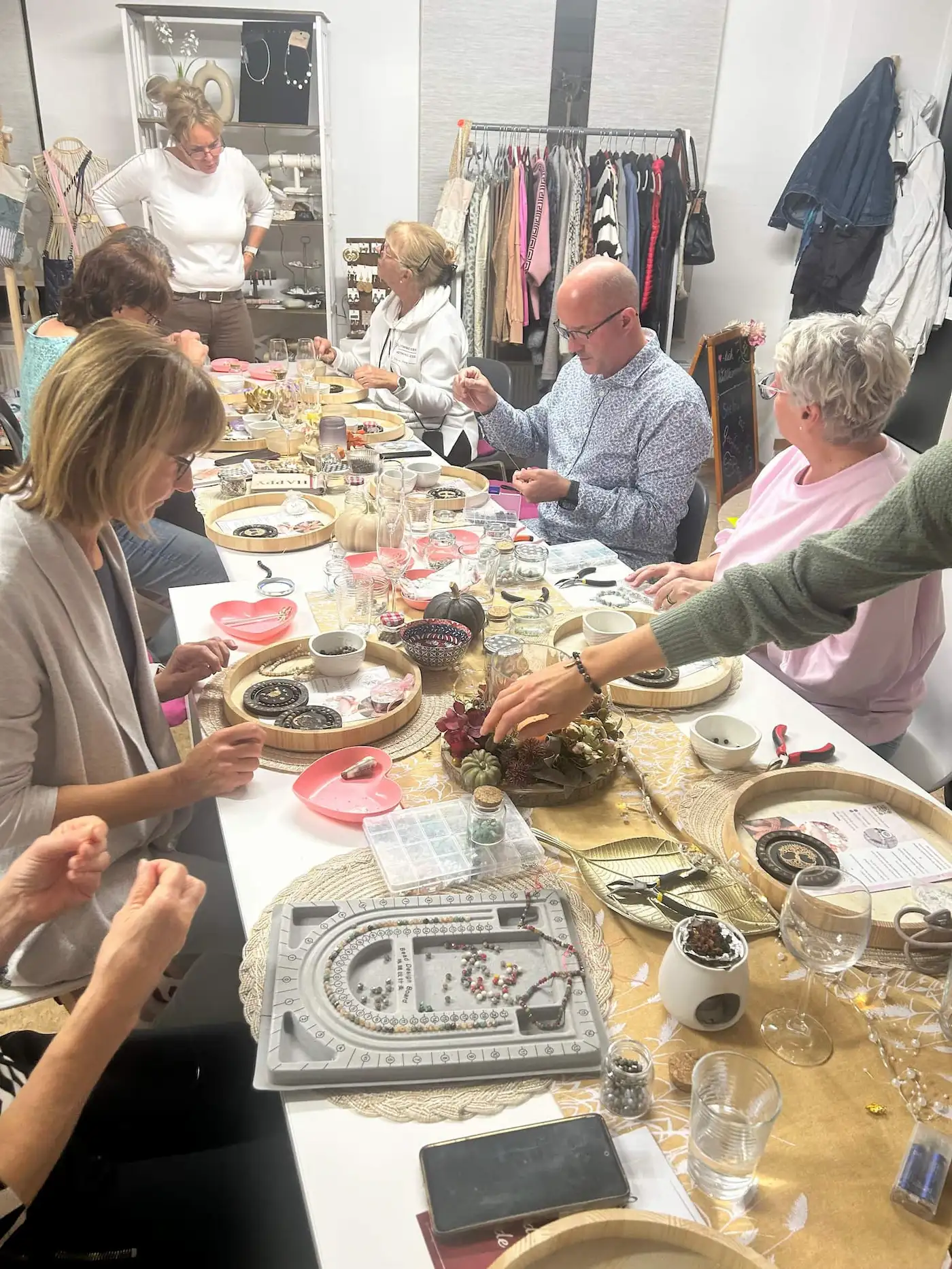 Eine Teilnehmerin fädelt Perlen für ihr Armband auf